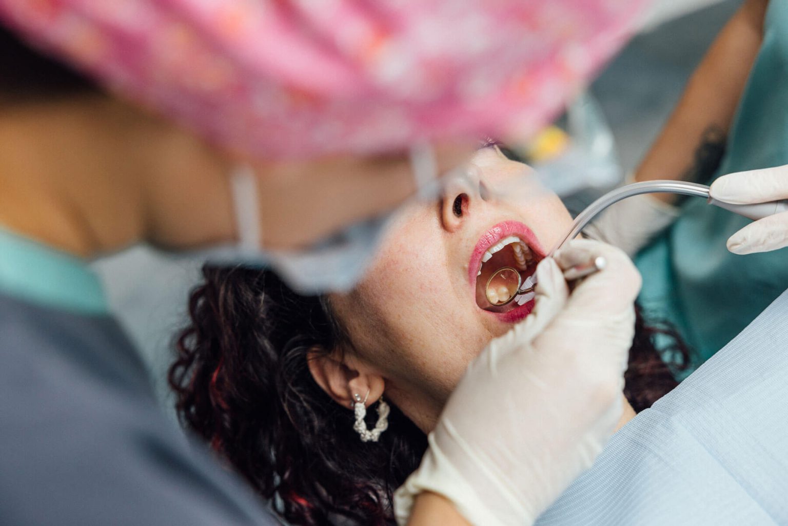 Observação dos dentes com espelho e instrumentos durante uma consulta dentária.