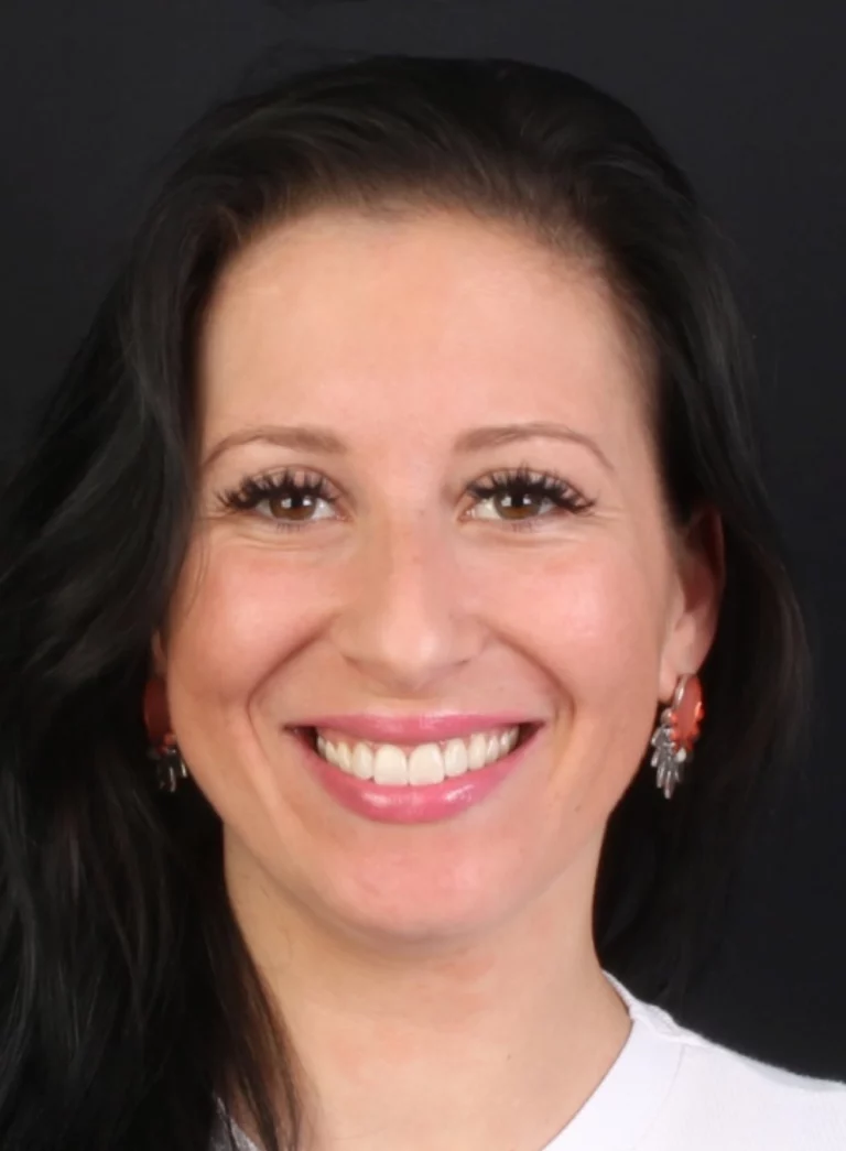 Retrato frontal de uma mulher de cabelo escuro a sorrir.