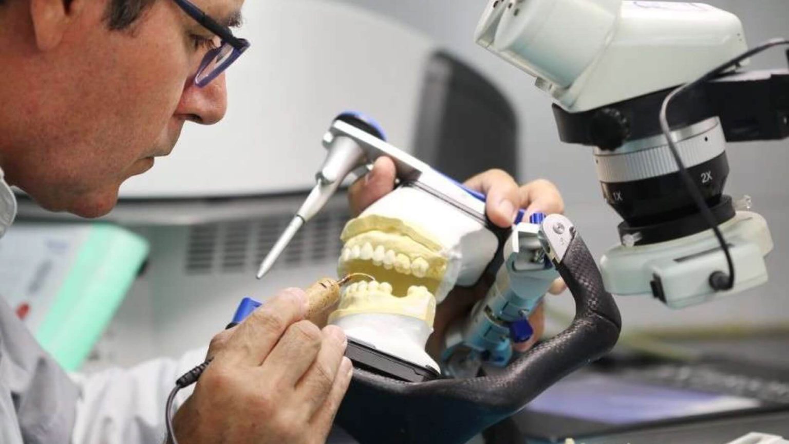 Profissional a trabalhar num modelo de arcadas dentárias num laboratório.