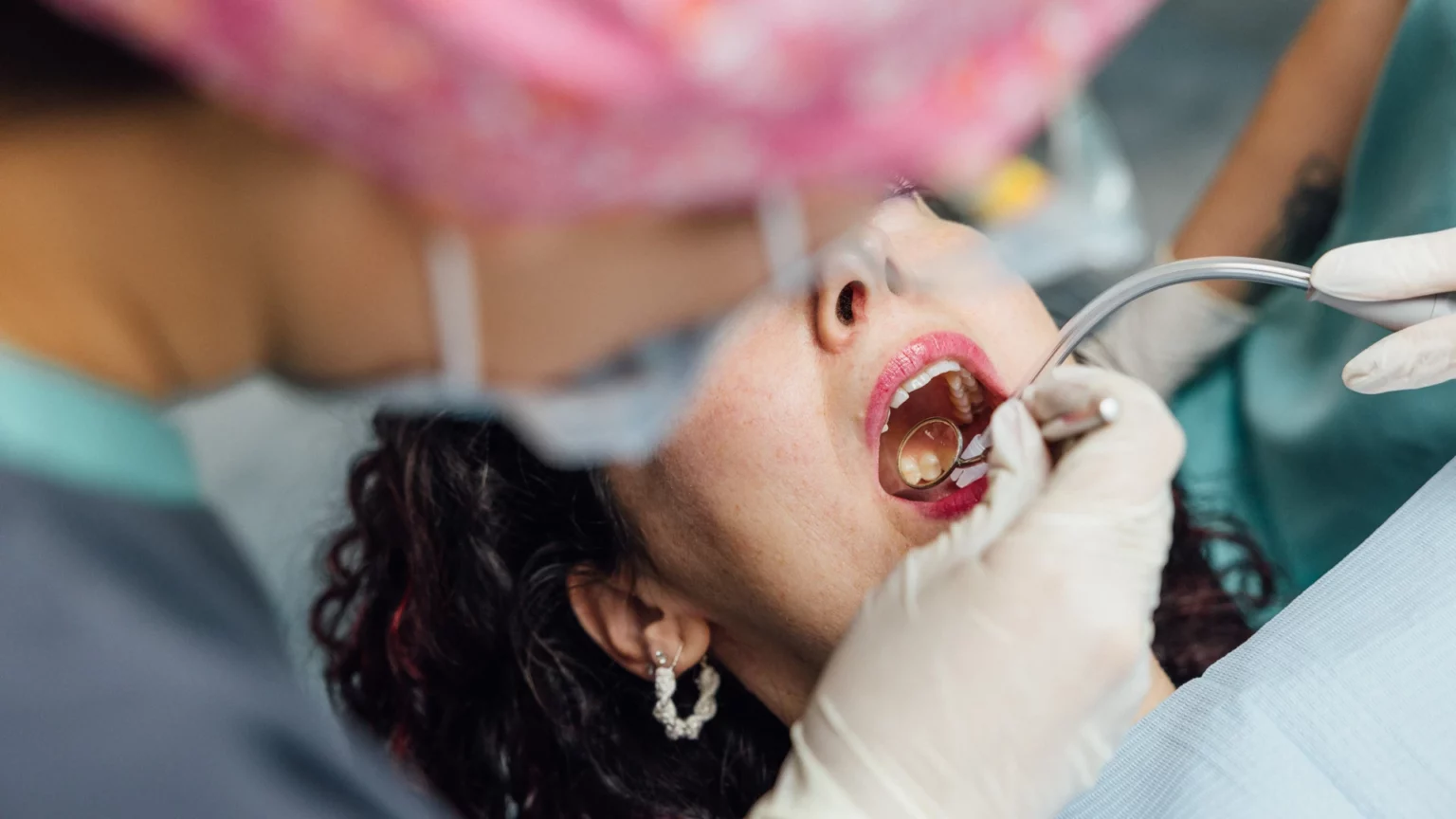 Observação da boca com um espelho e instrumentos dentários.